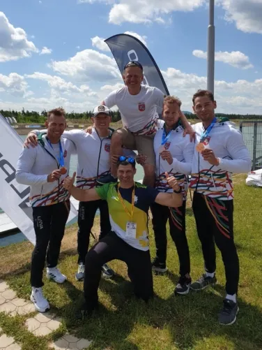 Bronzą Pasaulio taurės etape iškovojusi keturvietės baidarės įgula (iš kairės) S.Maldonis, I.Navakauskas, A.Seja ir M.Maldonis su treneriu R.Petrukanecu (viršuje) ir kineziterapeutu J.Vaščenkovu (LBKIF nuotr.)